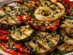 Fuente con verduras grilladas de berenjena, zucchini, morrón y cebolla, marcadas por la plancha y cubiertas con provenzal en aceite de oliva