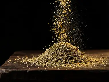 Orégano seco cayendo en montón sobre una tabla de madera oscura